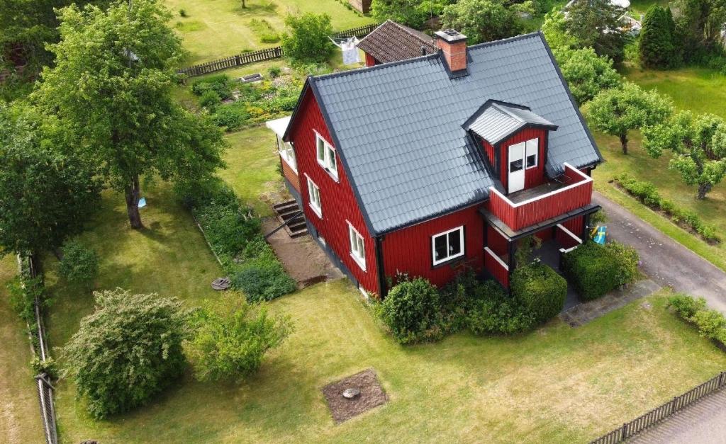 eine Aussicht auf ein rotes Haus auf einem Feld in der Unterkunft Buntes Schwedenhaus Lillebror in Fågelfors