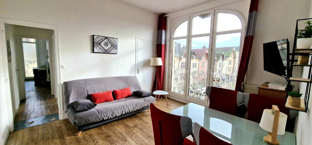 a living room with a couch and a large window at Au Coeur de Ville in Troyes