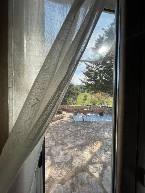 een raam met uitzicht op een patio buiten bij La Mia Lamia in Cisternino