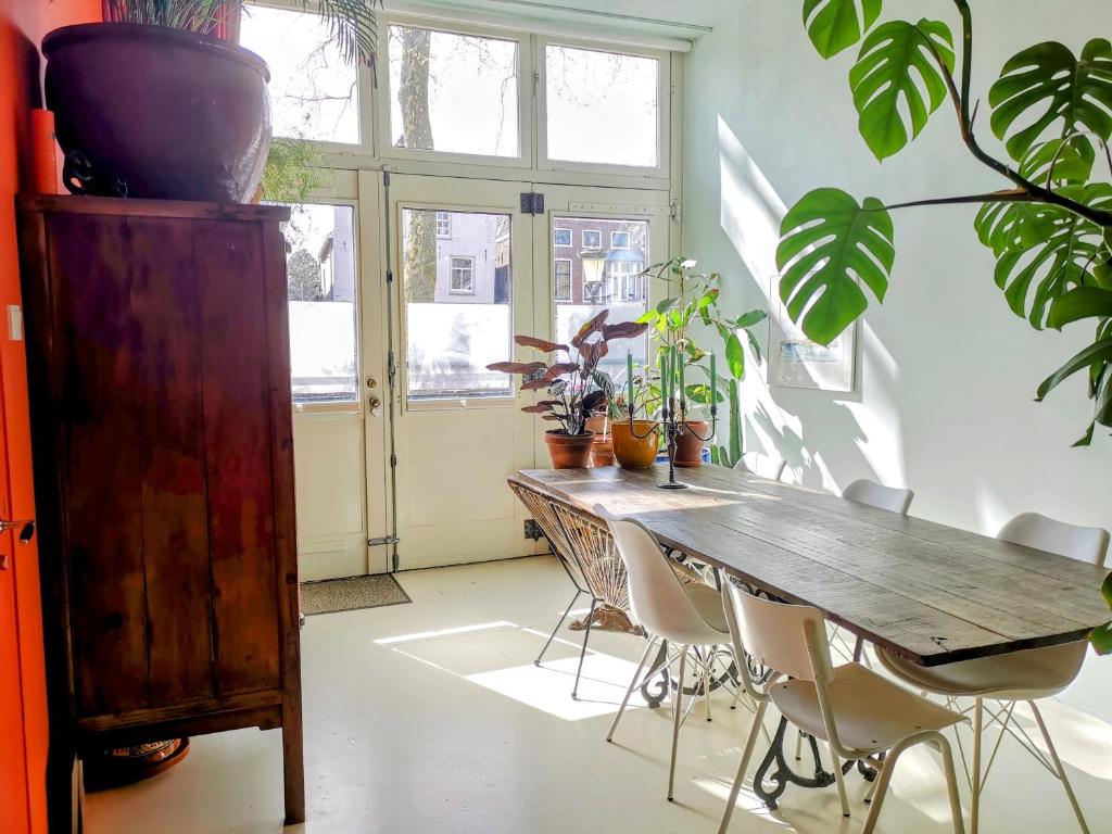 a dining room with a wooden table and some plants at Slapen aan de Sluis in Utrecht