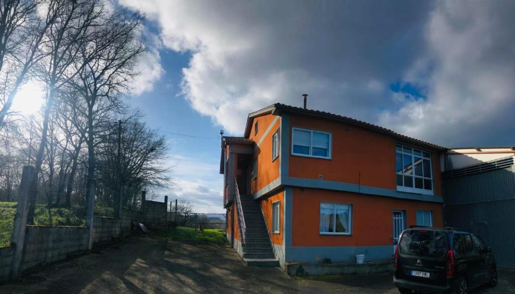 Armeses的住宿－Casa Aricel，一座橙色的房子,旁边设有停车场