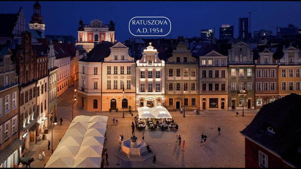 a group of buildings in a city at night at STARY RYNEK Old Market Square PREMIUM Apartments & Restaurant Ratuszova AD 1954 room service & mini bar in Poznań