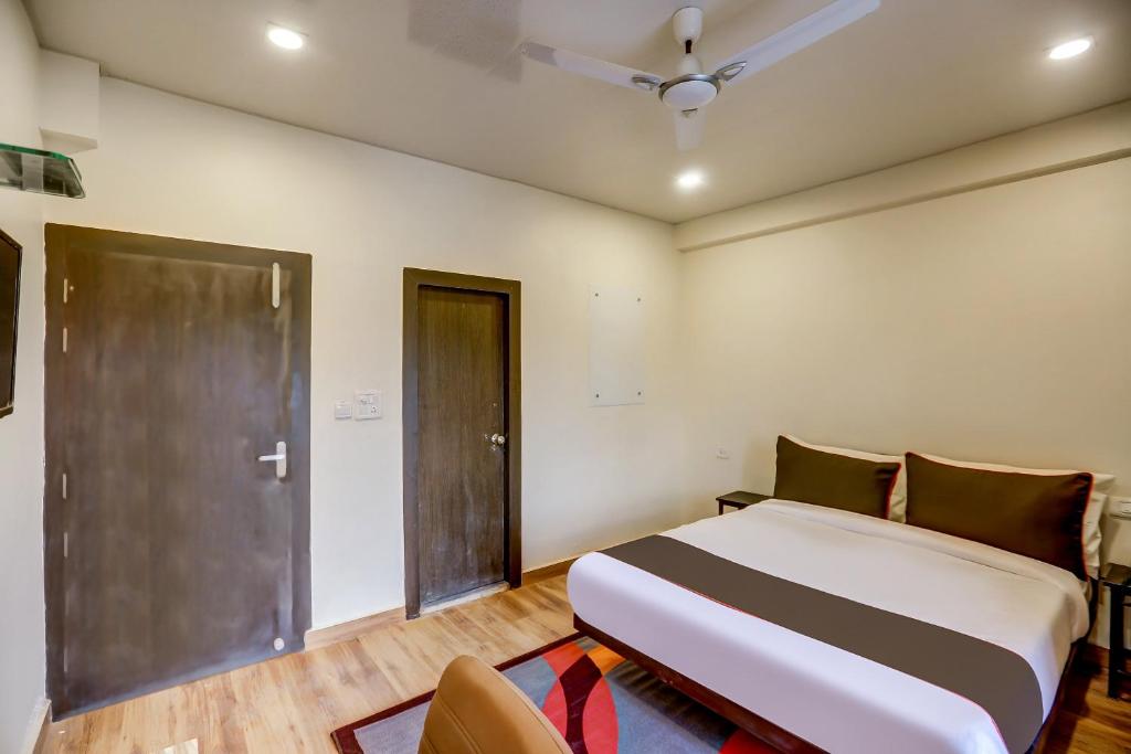 a bedroom with a large bed and a door at Collection O Sr Inn Awas Vikas in Kānpur