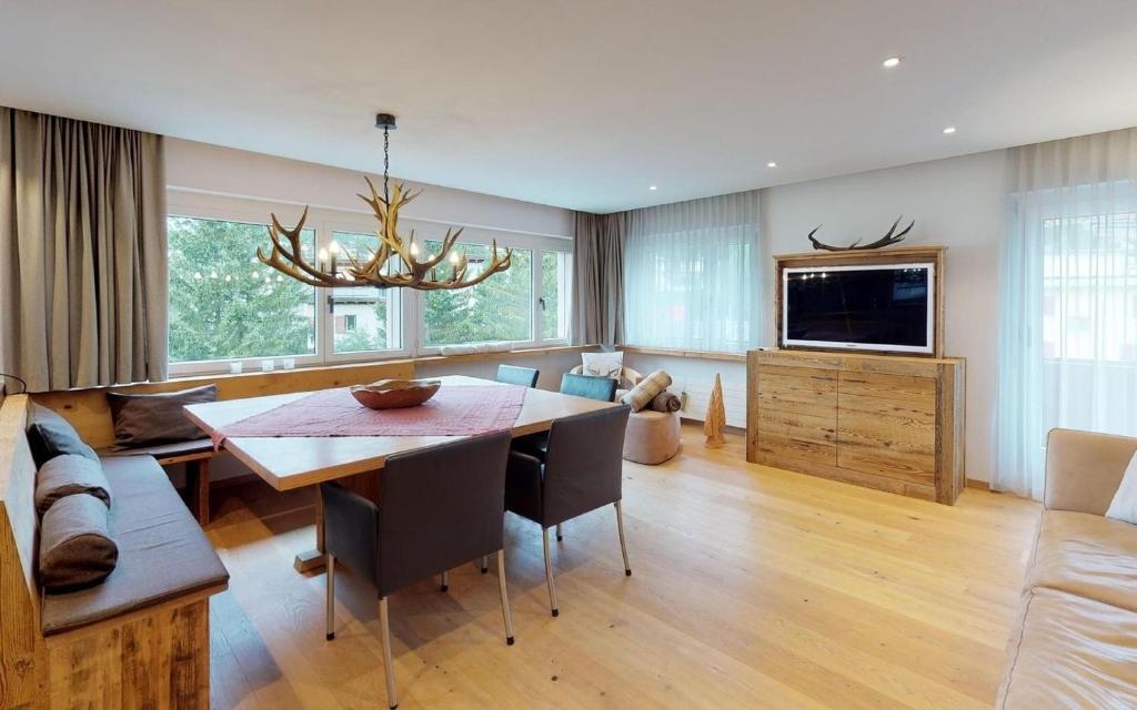 - un salon avec une table à manger et une télévision dans l'établissement Casa Polo, à Saint-Moritz