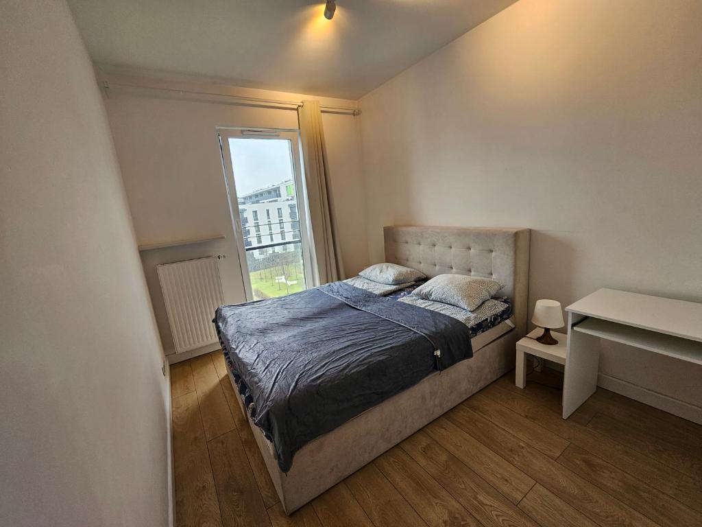 niewielka sypialnia z łóżkiem i oknem w obiekcie FIRST -- Green Żoliborz Apartment 2 w Warszawie