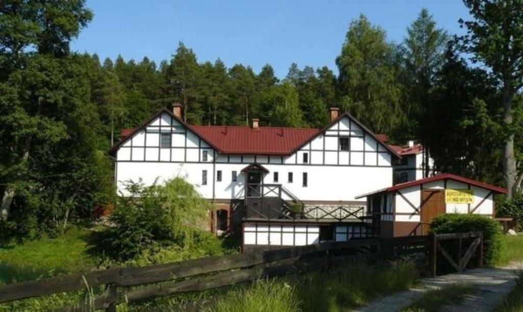 un gran edificio blanco con techo rojo en Ferienhaus in Kawczyn mit Kleiner Terrasse, en Miastko