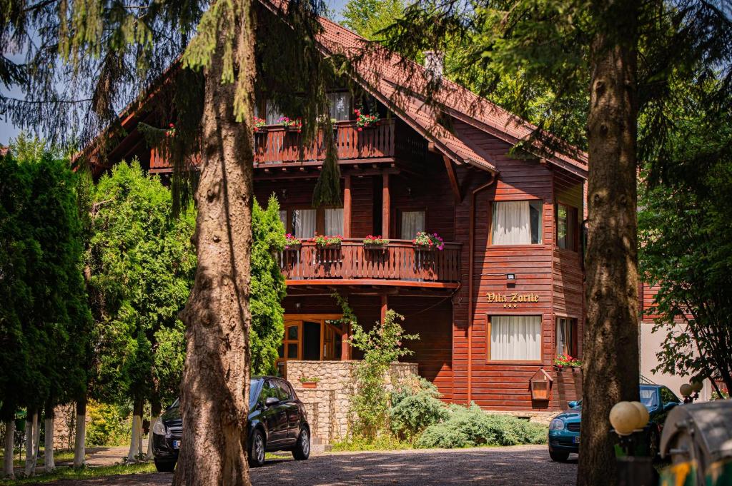 a large wooden house with a balcony at Vila Zorile in Poiana Brasov