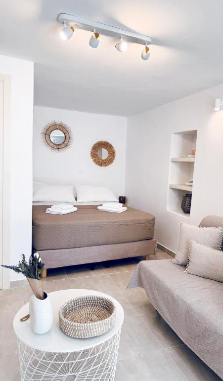 a bedroom with a bed and a couch and a table at Moma Apartment in Kithnos
