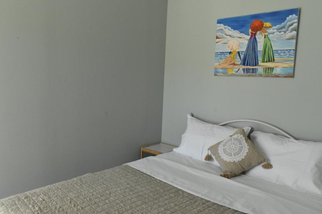 Natalia guest house في كافالا: غرفة نوم بسرير مع صورة على الحائط