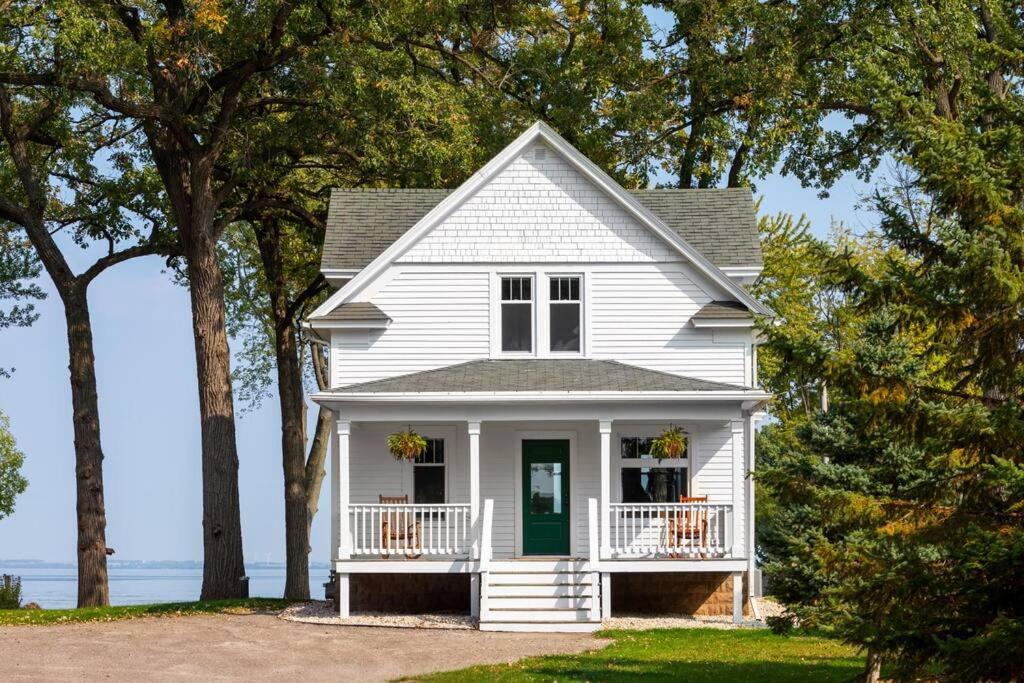 una casa bianca con portico e alberi di Goyke -Gorgeous Lakefront a Van Dyne