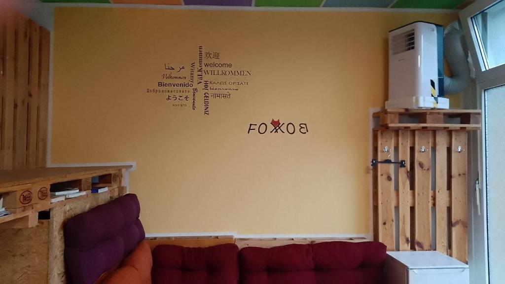FOX BOX I Capsule Apt في درسدن: غرفة معيشة مع أريكة وكتابة على الحائط