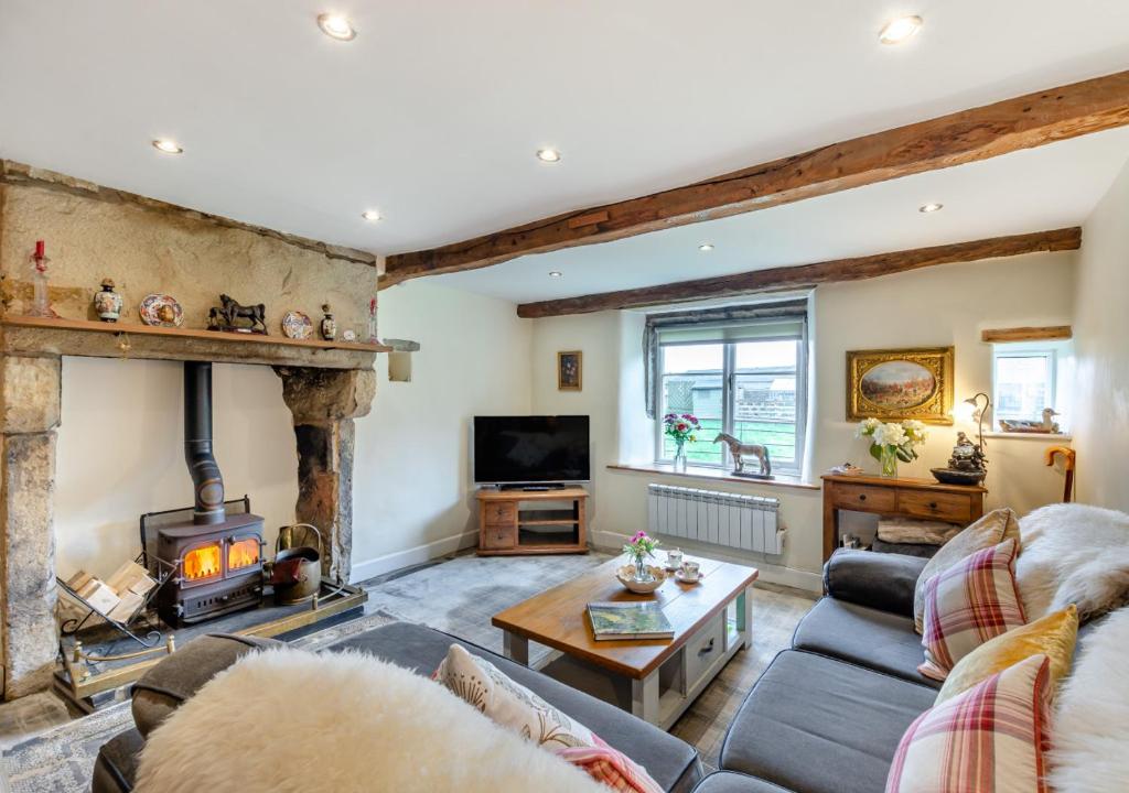 sala de estar con chimenea y TV en Newby Cottage en Newby