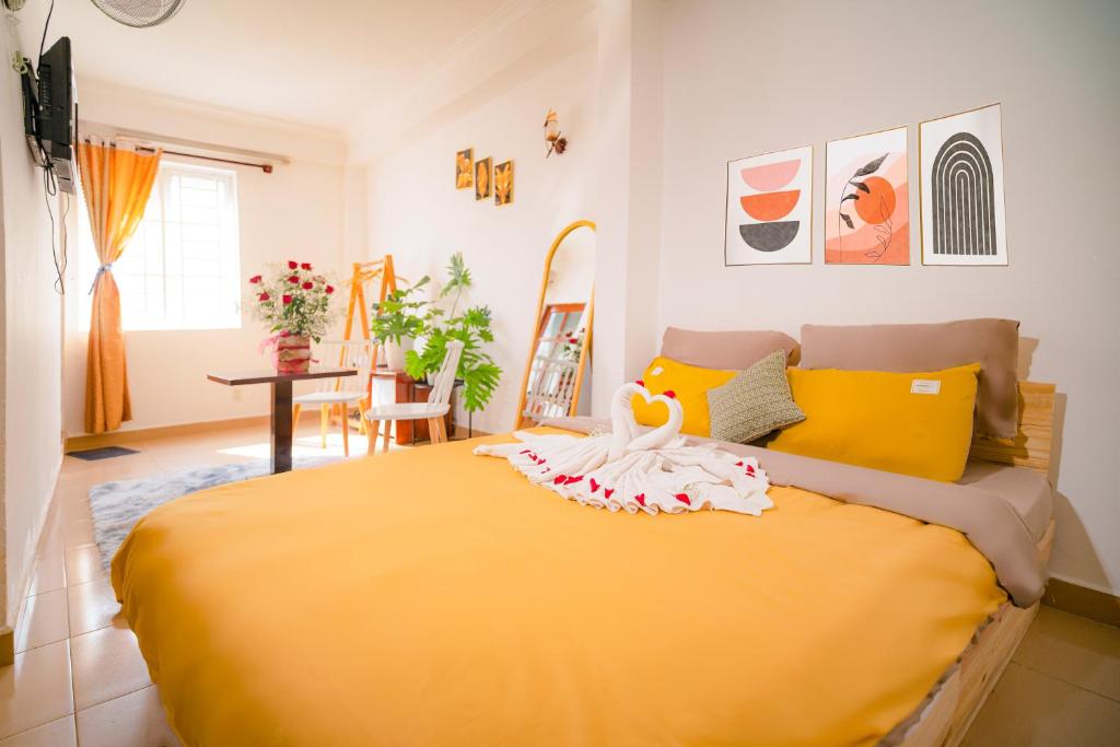a bedroom with a large yellow bed with a swan on it at Wealth Pearl Dalat Hotel in Da Lat
