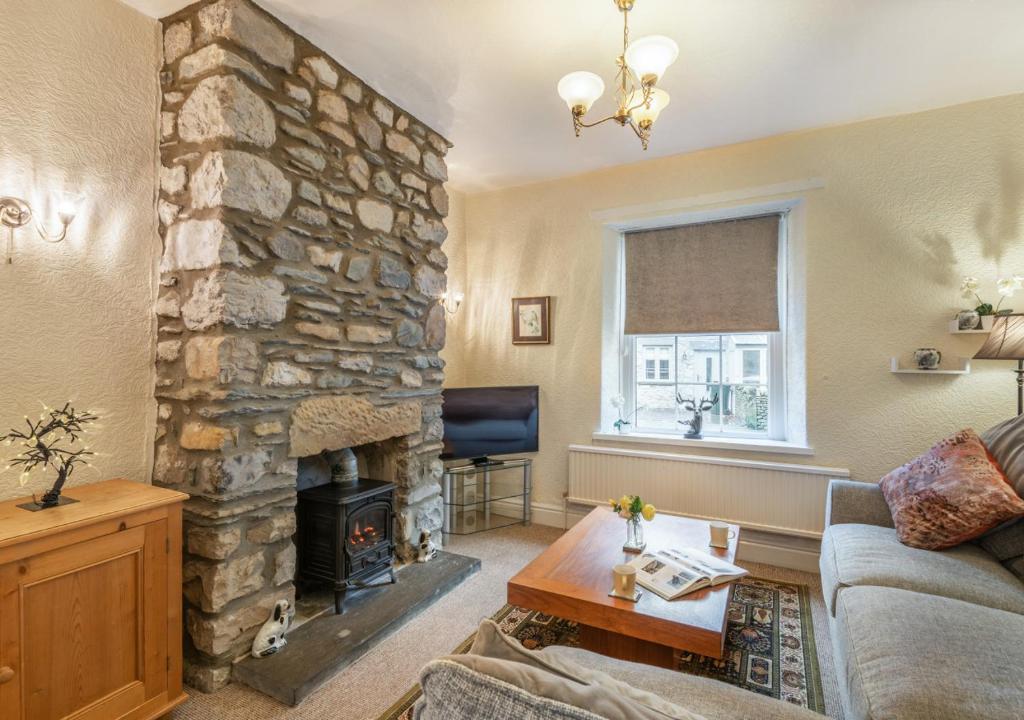 a living room with a large stone fireplace at Viaduct View in Ingleton