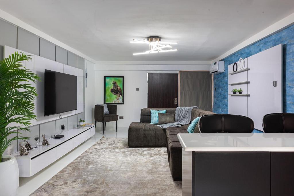 a living room with a couch and a tv at Blue Haven by Sunspot Global Properties Ltd. in Abuja