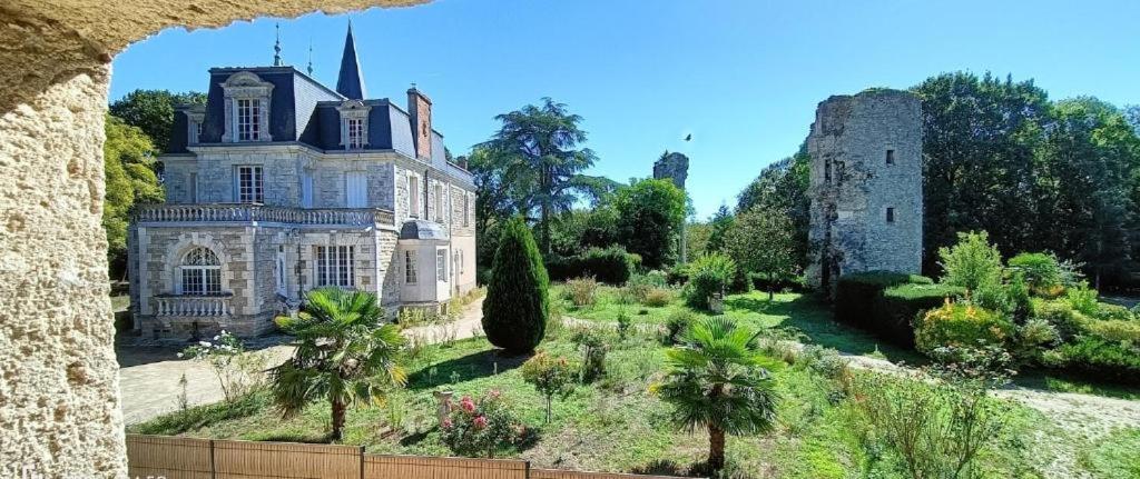 um velho castelo com árvores e arbustos à sua frente em LES DOUCEURS DU LOGIS em La Garnache