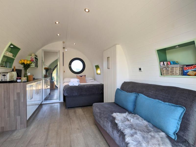 a living room with a couch and a bedroom at The Heron's Tree in Llandovery