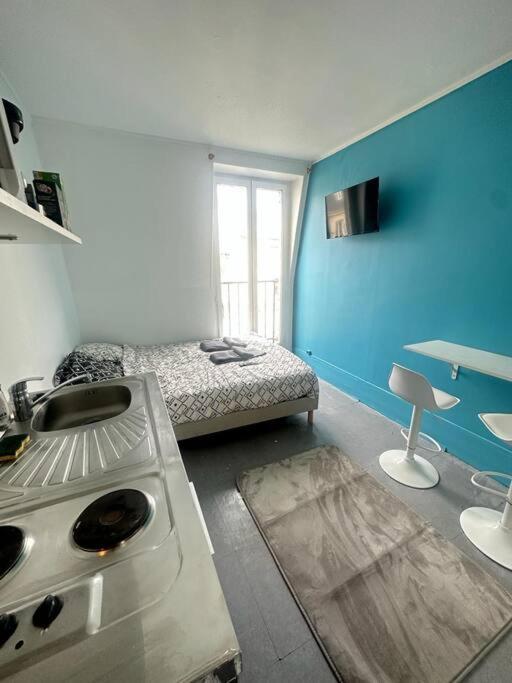 een keuken met een bed en een fornuis in een kamer bij Studio cosy - Paris 16 in Parijs