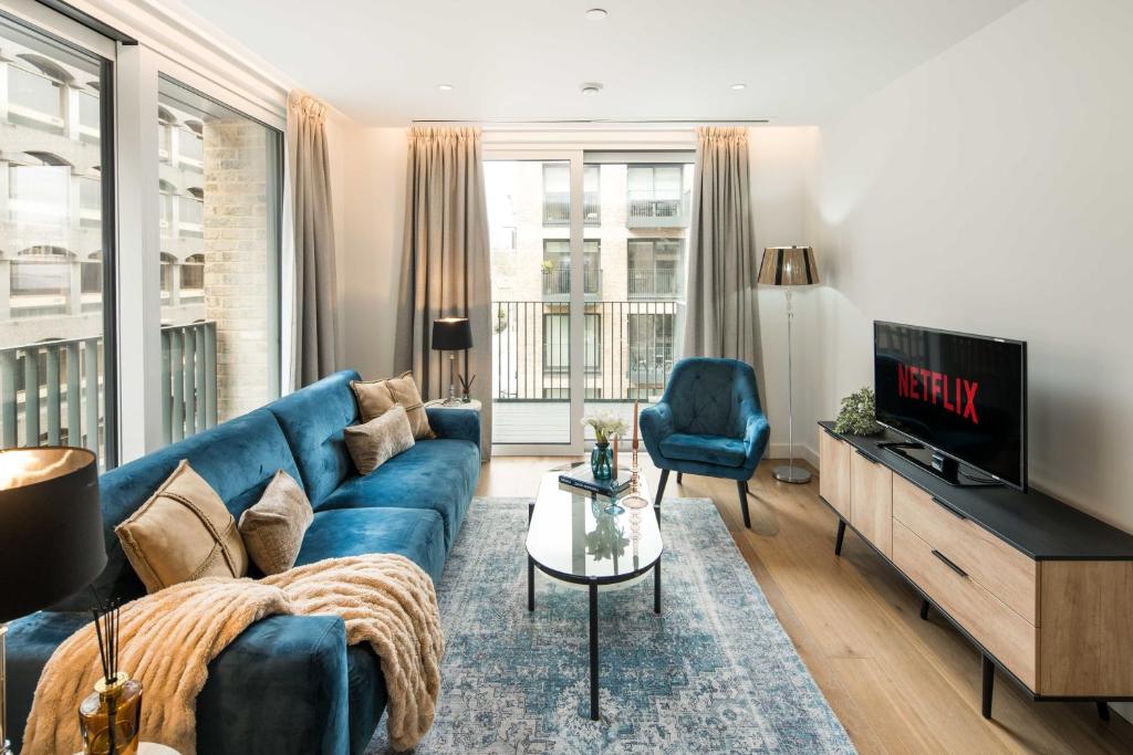 a living room with a blue couch and a tv at Covent garden-British museum-London university-central in London