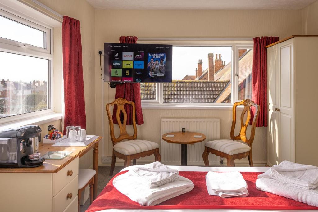 Zimmer mit einem Bett, einem Tisch und einem Fenster in der Unterkunft The Kildare in Skegness