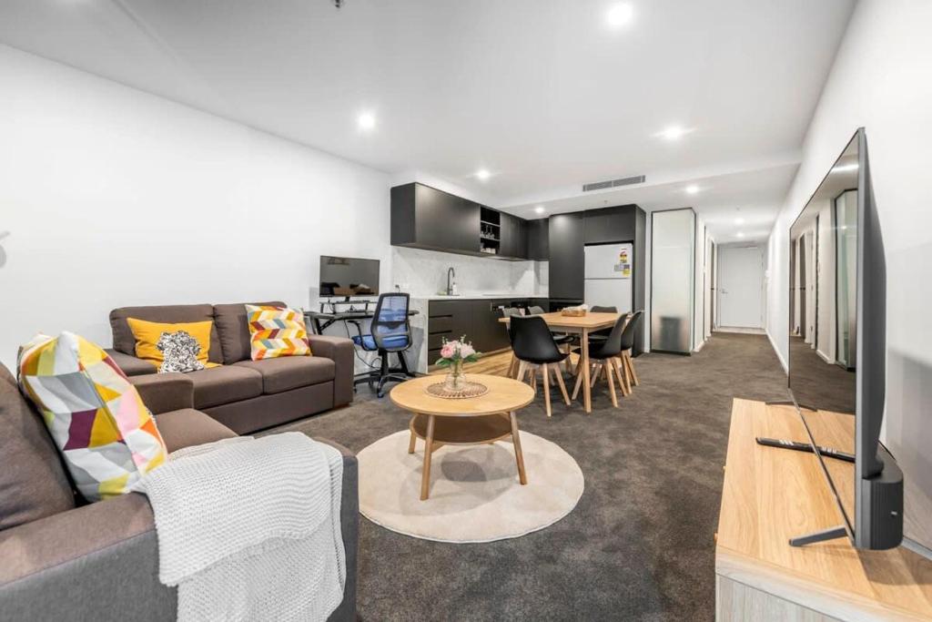 a living room with a couch and a table at Park Ave City delight in Canberra
