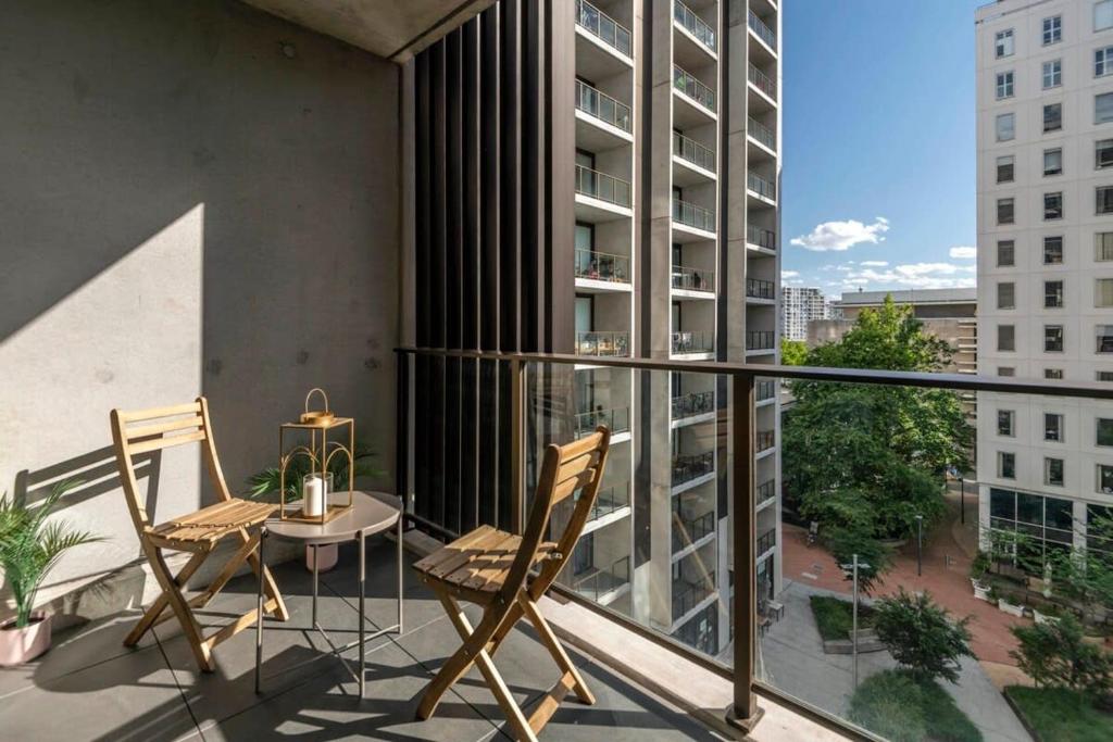 un balcón con 2 sillas y una mesa en un edificio en London Circuit City Escape, en Canberra