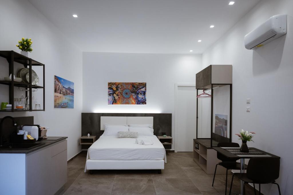 ein Schlafzimmer mit einem weißen Bett und einem Schreibtisch in der Unterkunft Family House in Cefalú