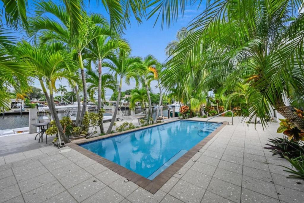a swimming pool with palm trees in a resort at Casa del Sol in Fort Lauderdale