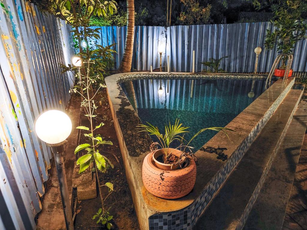 a swimming pool with plants next to a fence at Blue Lagoon 2bhk in Lonavala