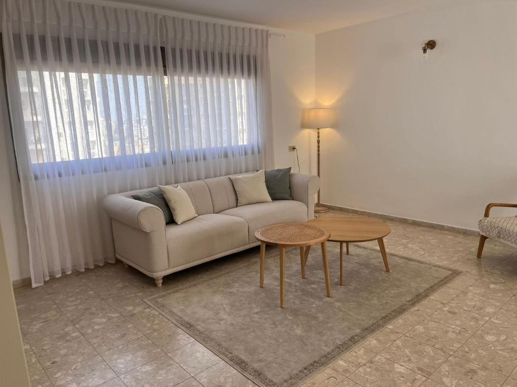 een woonkamer met een bank en een tafel bij Kosher for Passover Beachfront Apartment in Netanya