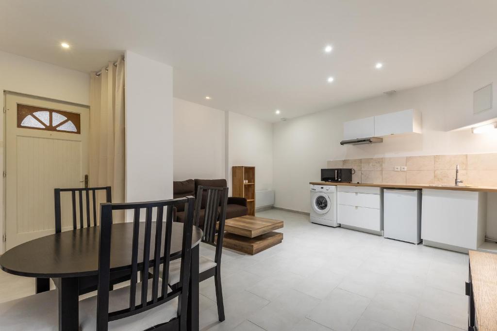 une cuisine et une salle à manger avec une table et des chaises dans l'établissement Studio proche de Béziers centre, à Béziers
