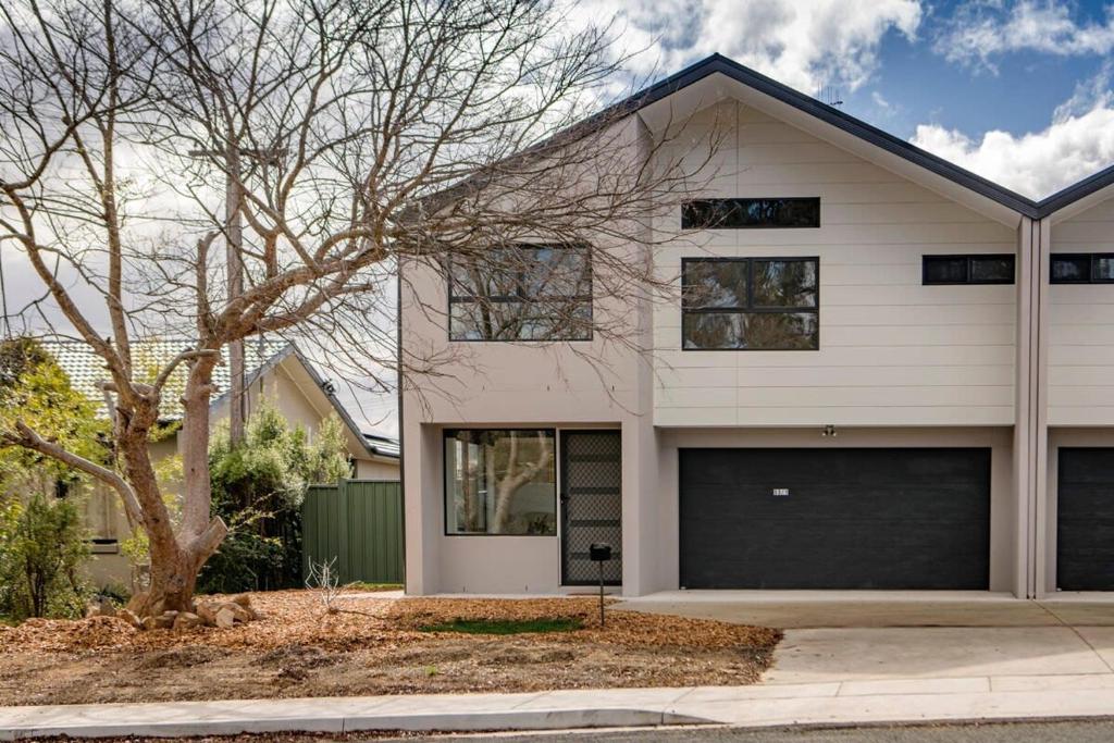 a white house with two garage doors at Sensational New Townhouse in Canberra