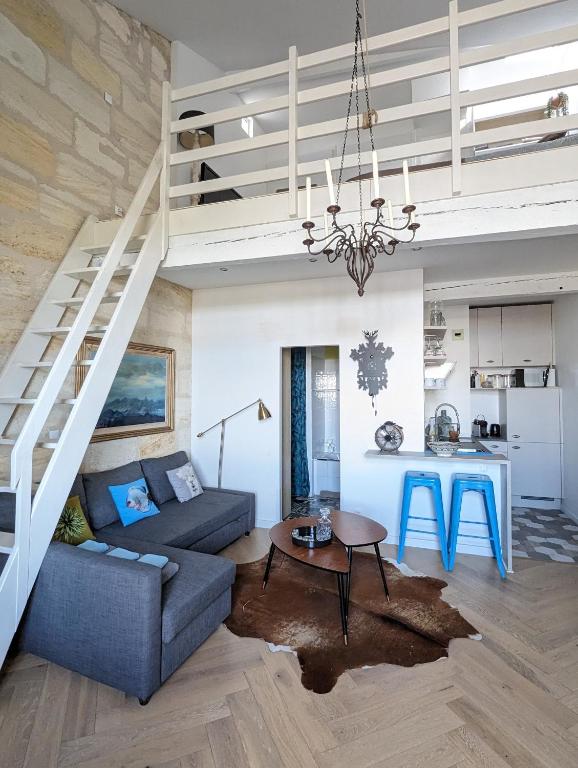 un salon avec un canapé et une table dans l'établissement Appartement de charme sous les toits avec vue sur la Garonne, à Bordeaux