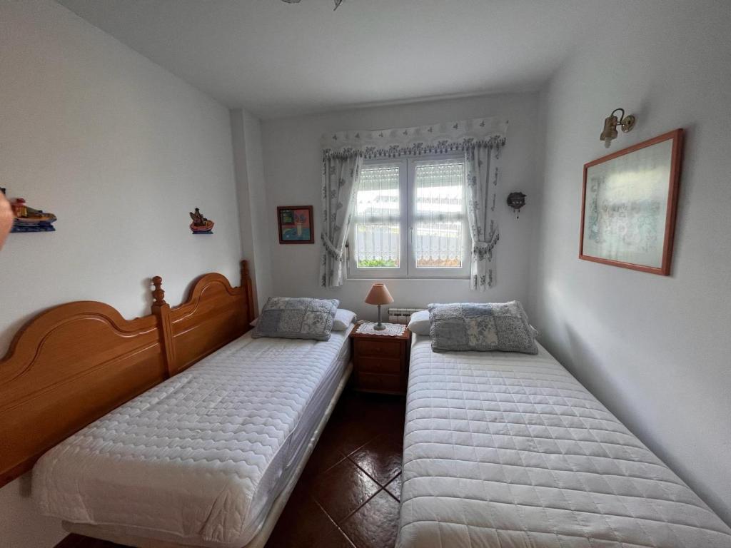 um quarto com 2 camas e uma janela em Costa Comillas Villa Rosa em Comillas