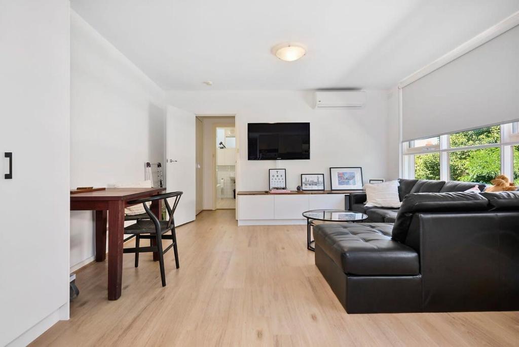 a living room with a couch and a table at Chic Elwood 1BR Apt with Free Parking in Melbourne