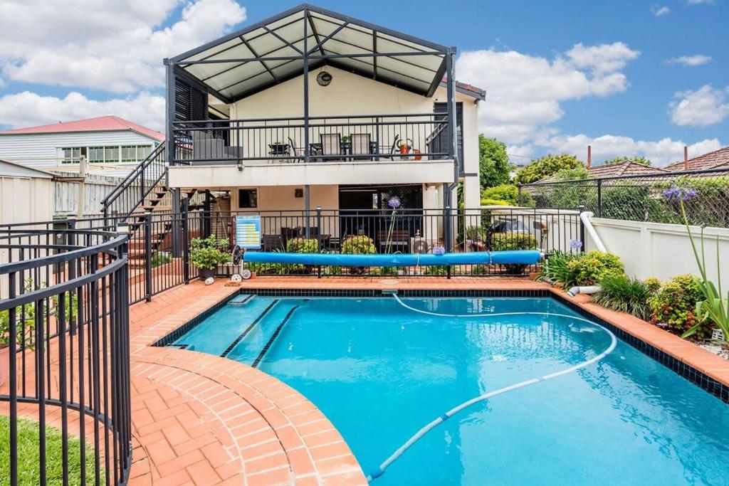 a swimming pool in front of a house at Seaside Serenity at Plumeria Place in Brisbane