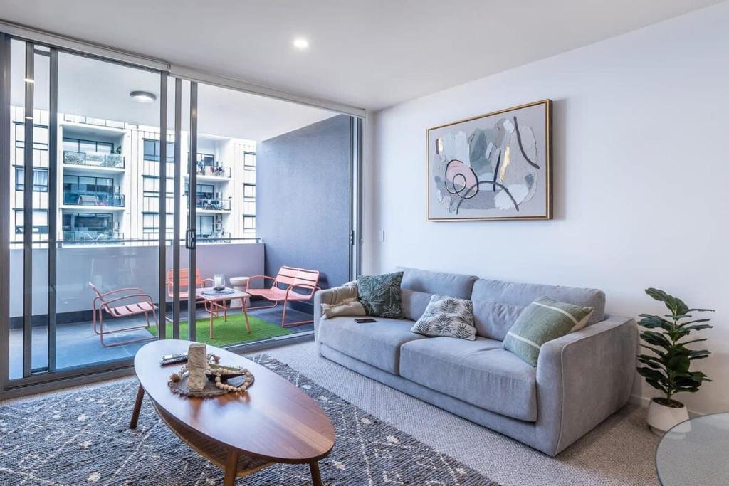 a living room with a couch and a table at Stylish Apartment with Rooftop Pool in Brisbane