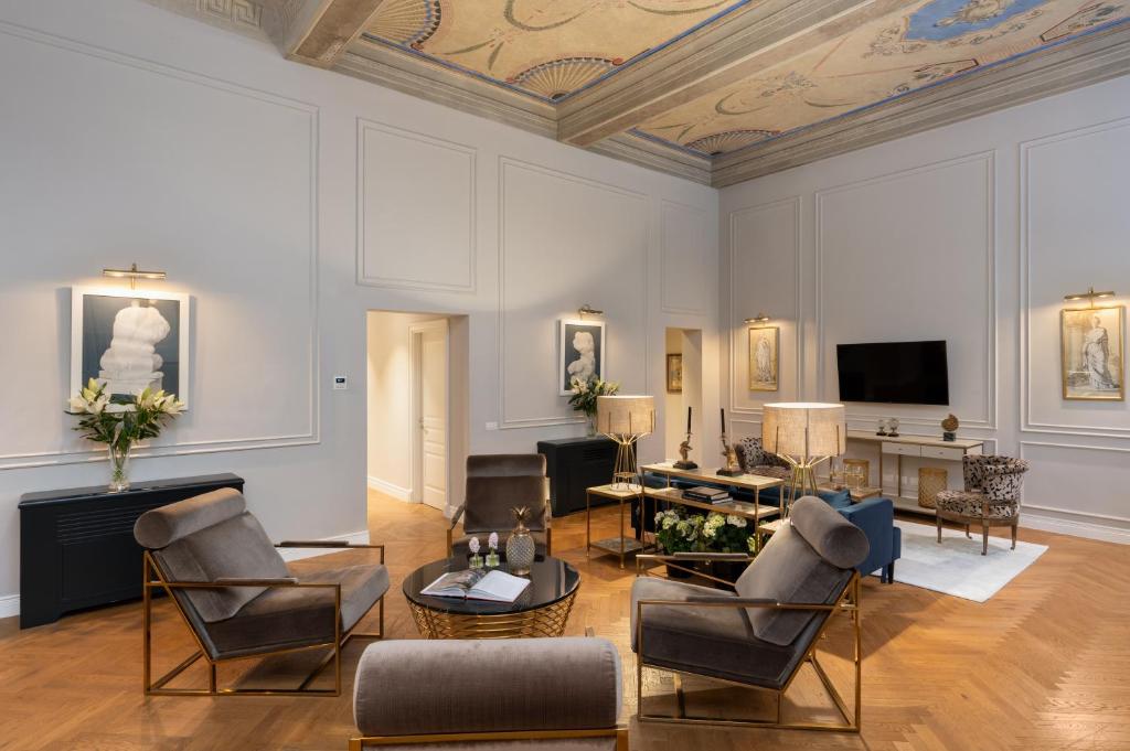 sala de estar con sillas, sofá y TV en Pazzi Penthouse Luxury Apartment In Florence By Palazzo Vitali en Florence