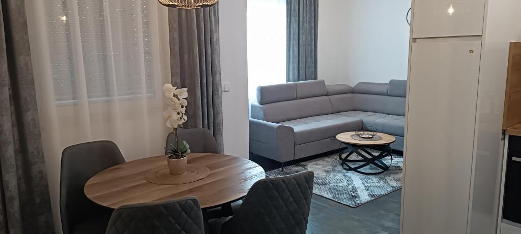 ein Wohnzimmer mit einem Tisch und einem Sofa in der Unterkunft Apartmani Sanja in Teslić