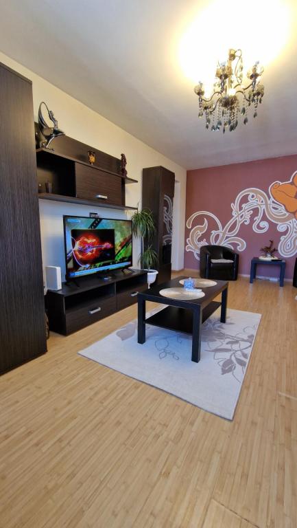 a living room with a table and a tv at MMT SweetHome 2 in Ploieşti