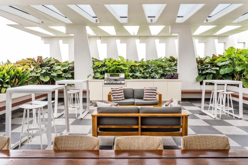 a lobby with tables and chairs and plants at Urban Luxury - Discover this City Escape in Brisbane
