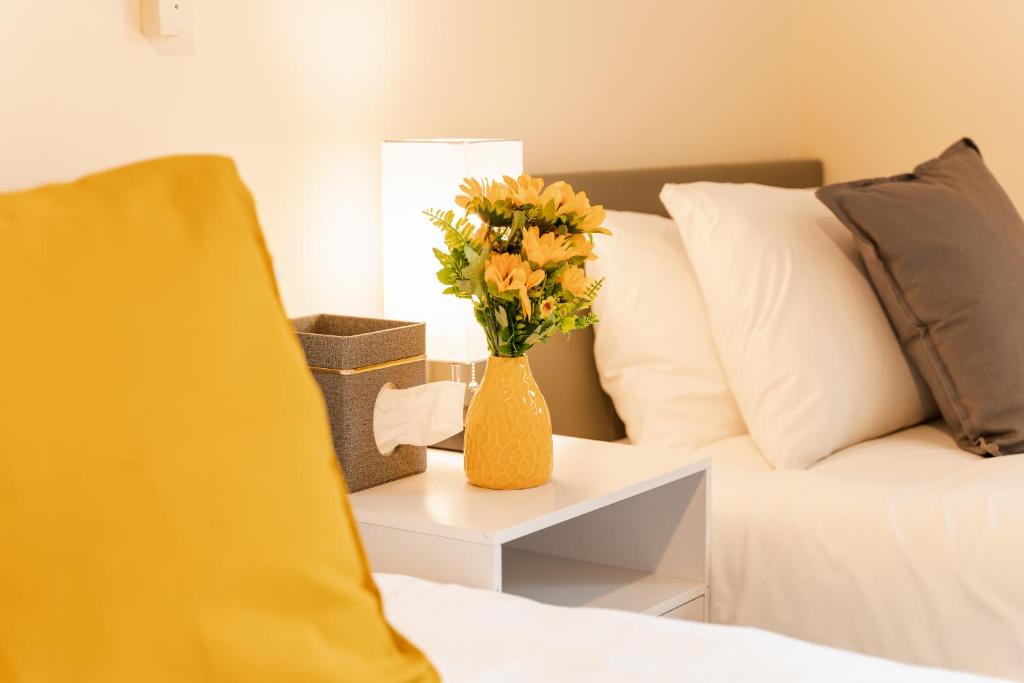 un vase de fleurs sur une table à côté d'un lit dans l'établissement Updated & central 2 bedroom Chester apartment - for up to 6, à Chester