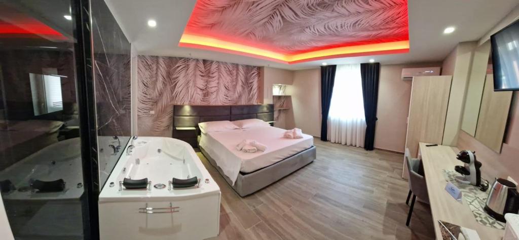 1 dormitorio con cama, lavabo y bañera en ARIA DI MARE LUXURY B&B, en Marina di Schiavonea