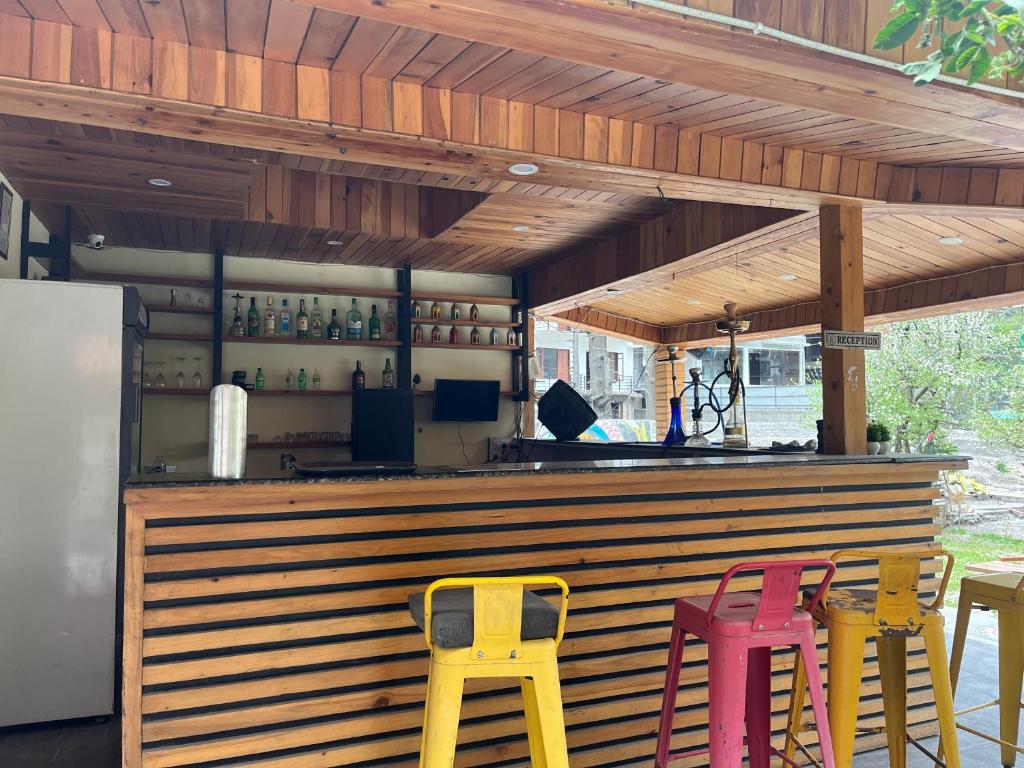 un bar con sgabelli gialli e rossi di fronte ad esso di The Lalits Kitchen a Kasol