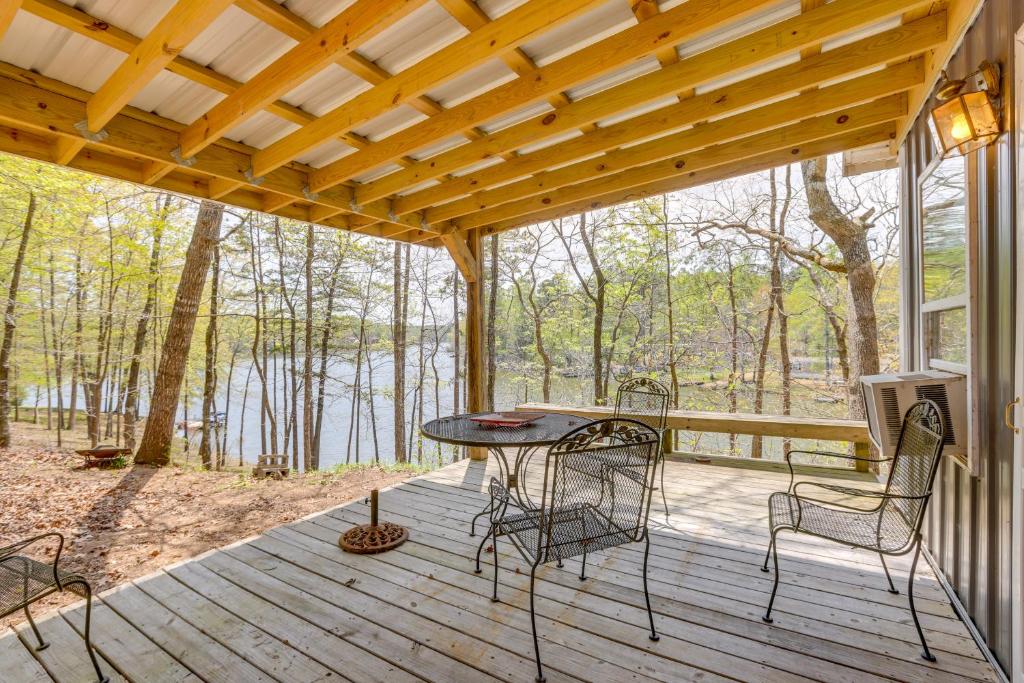 une terrasse en bois avec une table et des chaises. dans l'établissement Lakefront Delta Cabin Rental with Boat Dock and Deck!, à Delta