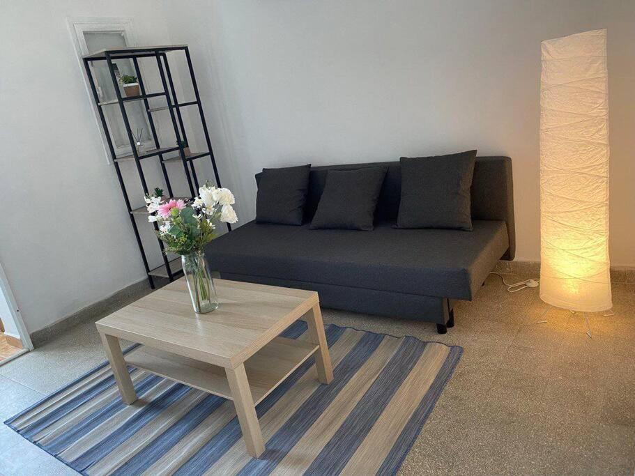 un soggiorno con divano e tavolo con fiori di Cozy apartment on the beach a Haifa