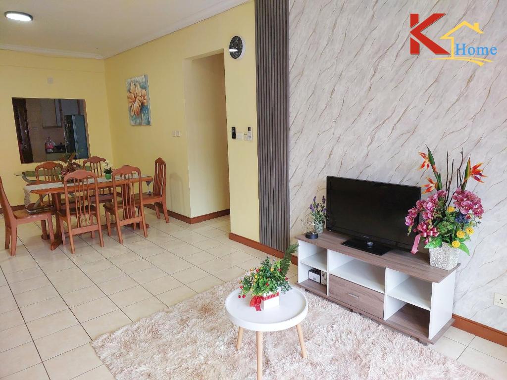 a living room with a tv and a table with flowers at KHome-MarinaCourt-KK CITY CENTRE .3B2R(8Pax) NEW!! in Kota Kinabalu