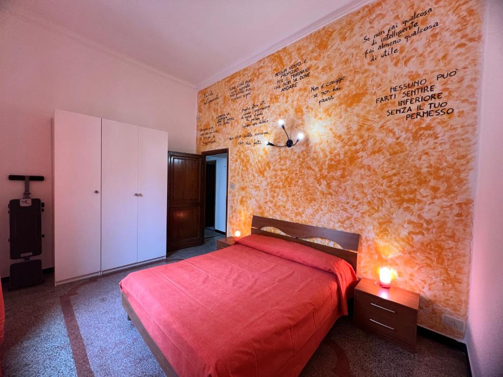 een slaapkamer met een rood bed met een opschrift op de muur bij Appartamento Grandis in Genua
