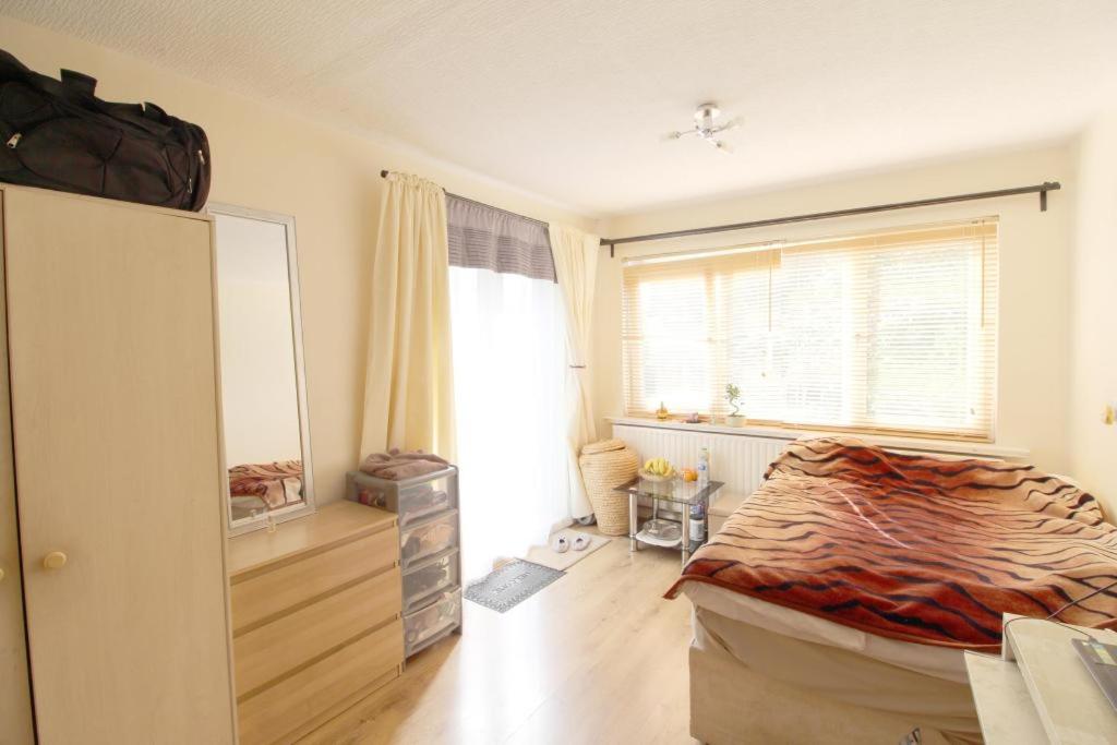 a bedroom with a large bed and a window at Ross Holiday Room in Sutton