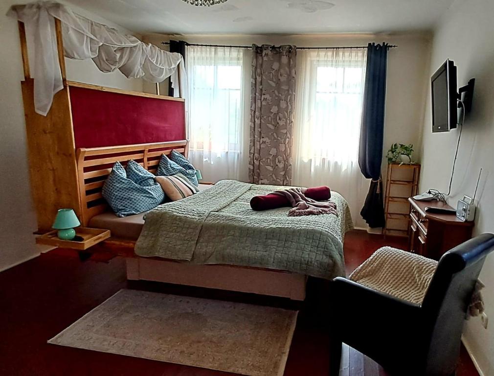 een slaapkamer met een bed, een stoel en ramen bij Gemütlichkeit am Vierkanthof - Apartment 1 in Wörterberg